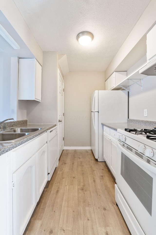 kitchen with sink, white appliances, white cabinets, and light wood-type flooring