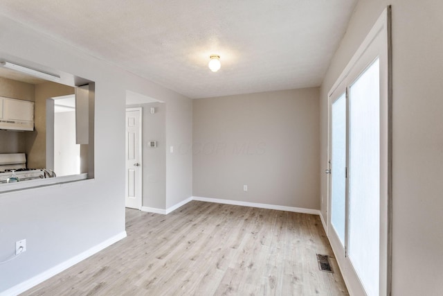 spare room featuring a textured ceiling and light wood-type flooring