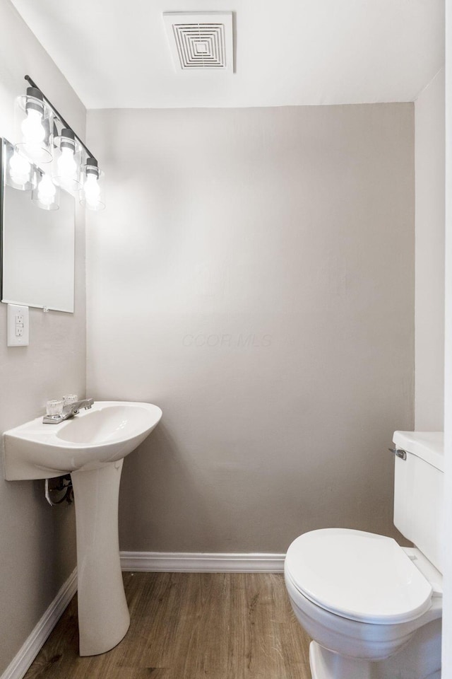 bathroom with sink, hardwood / wood-style flooring, and toilet