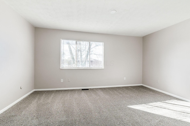 carpeted empty room with a textured ceiling