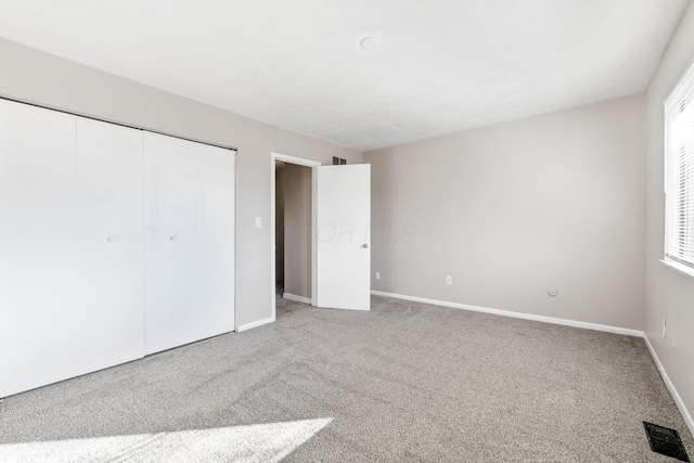 unfurnished bedroom featuring carpet floors and a closet