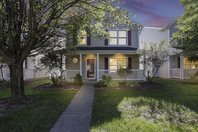 view of front facade with a porch and a lawn