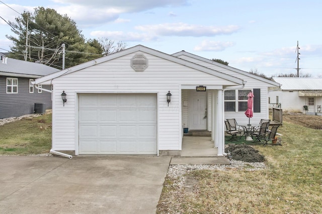 view of front of house with a garage, an outdoor structure, central AC unit, and a front yard