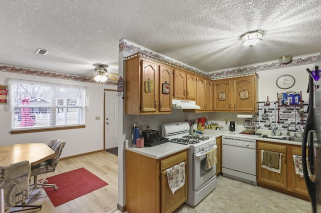 kitchen with sink, white appliances, ceiling fan, light hardwood / wood-style floors, and a textured ceiling