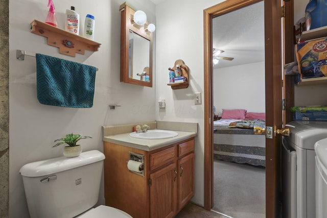 bathroom with vanity, washer and dryer, and toilet