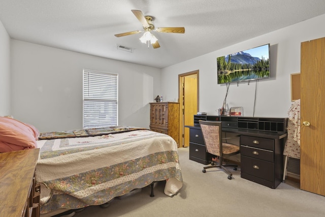 carpeted bedroom featuring a textured ceiling and ceiling fan