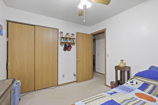 carpeted bedroom featuring a textured ceiling, ceiling fan, and a closet