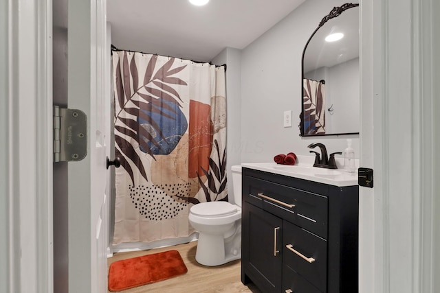 bathroom featuring wood-type flooring, a shower with shower curtain, vanity, and toilet