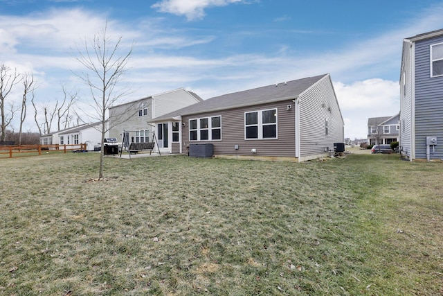 rear view of property featuring a patio, central AC, and a lawn