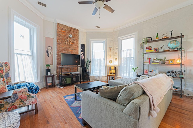 living room featuring ornamental molding, wood-type flooring, and ceiling fan