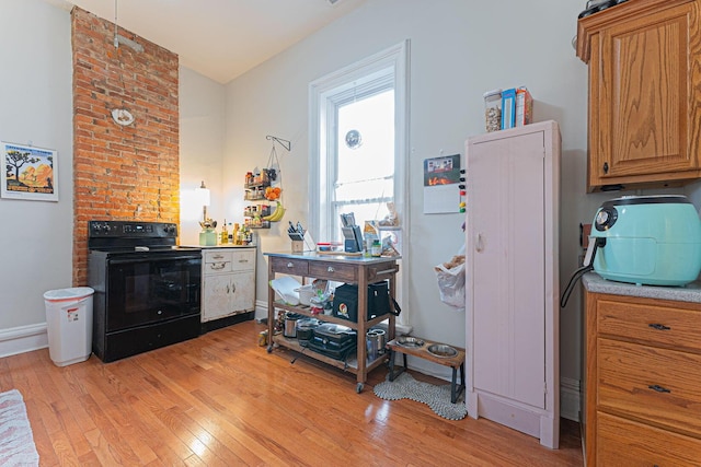 kitchen featuring black electric range oven and light wood-type flooring