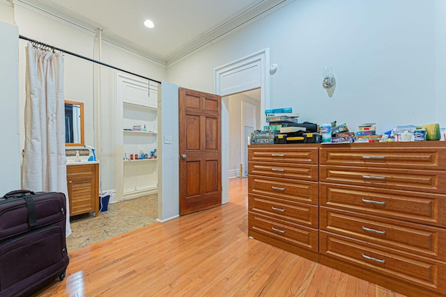 bedroom with ornamental molding and light wood-type flooring