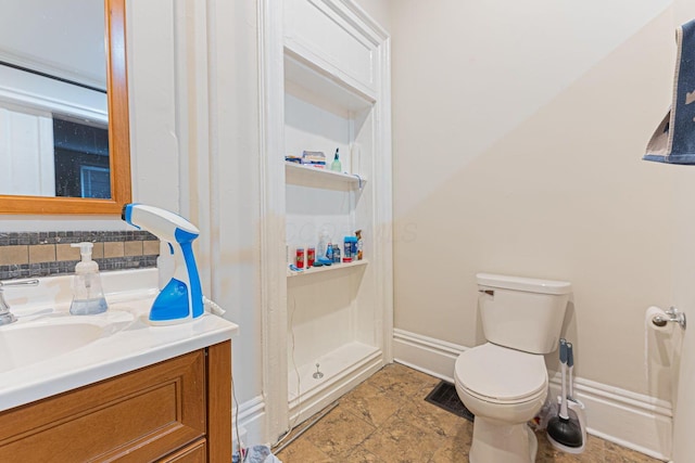 bathroom featuring vanity, backsplash, and toilet