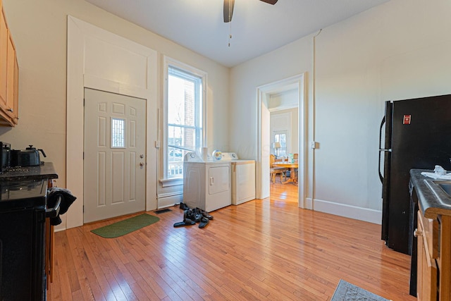 entryway featuring ceiling fan, washing machine and clothes dryer, and light hardwood / wood-style floors