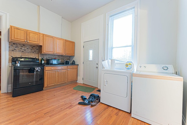 laundry area with separate washer and dryer and light hardwood / wood-style floors