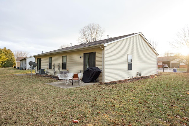 back of house with central AC, a yard, and a patio