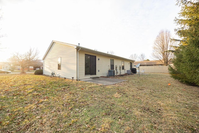 back of property with a lawn, a patio, and central air condition unit