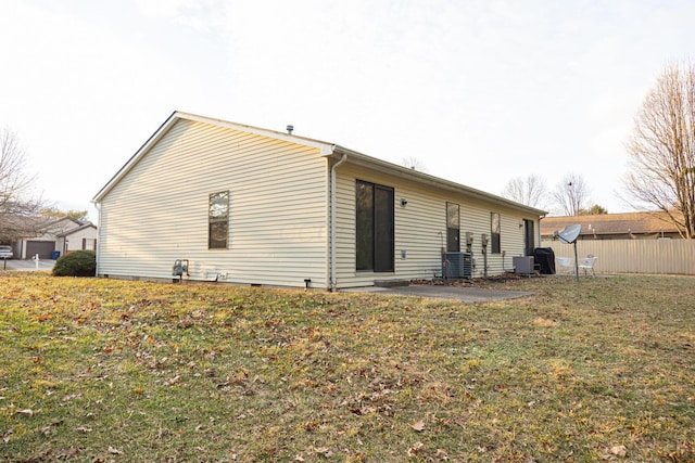 back of house featuring central AC unit and a lawn