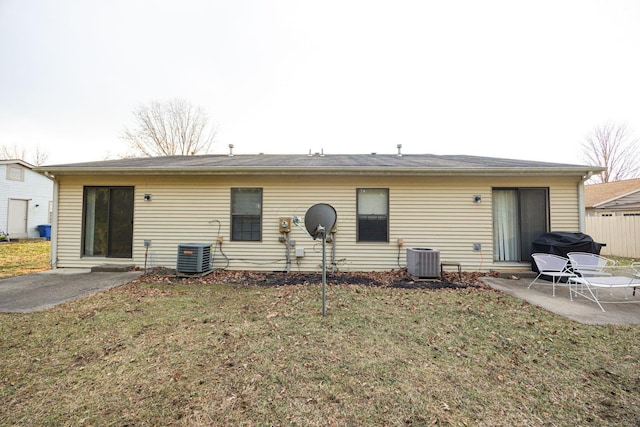 back of house featuring a lawn, a patio, and central air condition unit