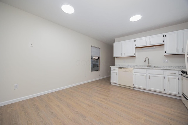 kitchen with white cabinets, sink, dishwasher, and light wood-type flooring