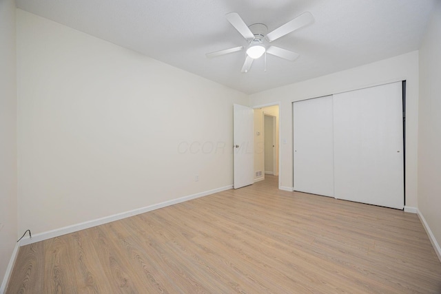 unfurnished bedroom with light hardwood / wood-style floors, a closet, and ceiling fan