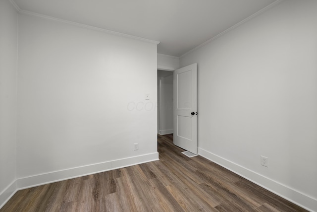 spare room featuring crown molding and hardwood / wood-style flooring