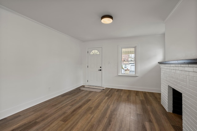 foyer entrance with a fireplace, ornamental molding, and dark hardwood / wood-style flooring