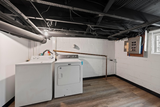 laundry room featuring dark hardwood / wood-style floors, electric panel, and washing machine and dryer