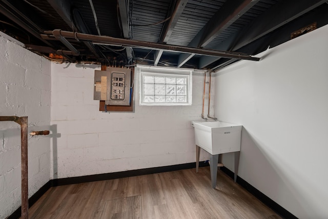 basement with electric panel and hardwood / wood-style floors