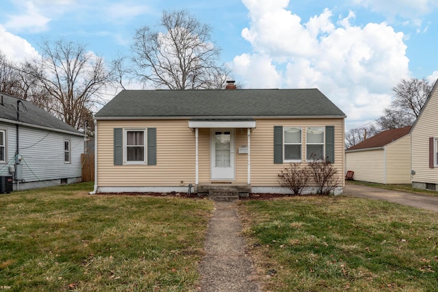 bungalow featuring a front yard and central air condition unit