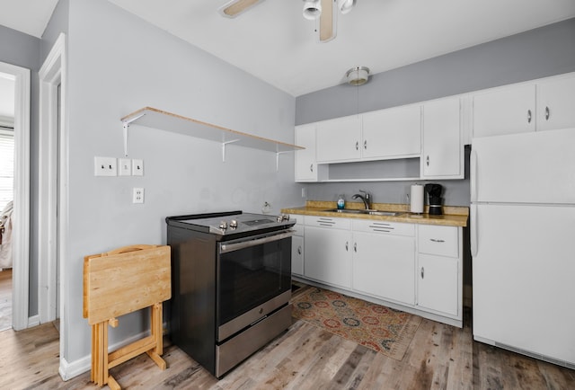 kitchen featuring sink, electric range, white cabinets, and white fridge