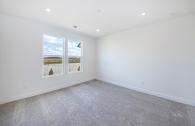 spare room featuring recessed lighting, carpet, visible vents, and baseboards