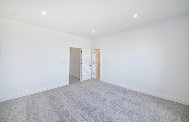unfurnished room featuring baseboards, recessed lighting, and light carpet