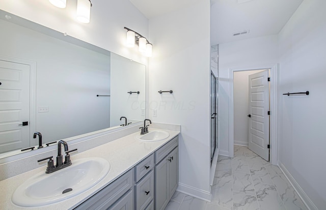 bathroom featuring a sink, baseboards, marble finish floor, and a stall shower