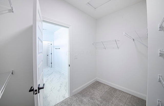 walk in closet with marble finish floor and carpet floors
