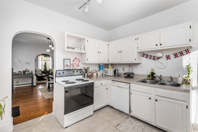 kitchen with sink, white cabinets, light hardwood / wood-style floors, track lighting, and white appliances