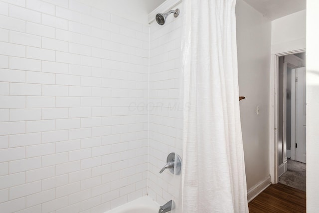 bathroom with shower / bath combination with curtain and wood-type flooring