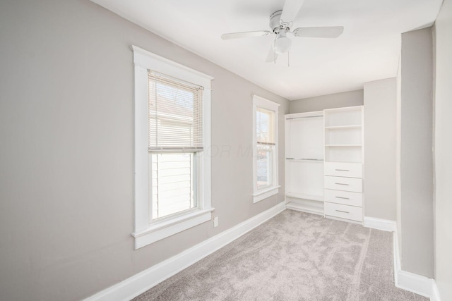 walk in closet featuring light carpet and ceiling fan