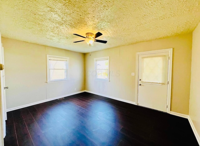 unfurnished room with ceiling fan, dark wood-type flooring, and a textured ceiling