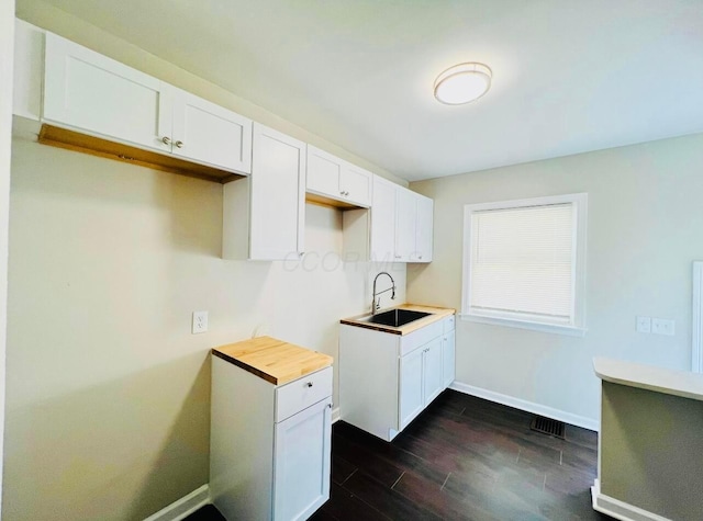 kitchen with white cabinetry, sink, and dark hardwood / wood-style flooring