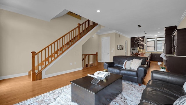 living room featuring crown molding and light hardwood / wood-style flooring