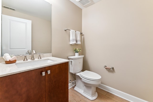 bathroom featuring visible vents, toilet, vanity, and baseboards