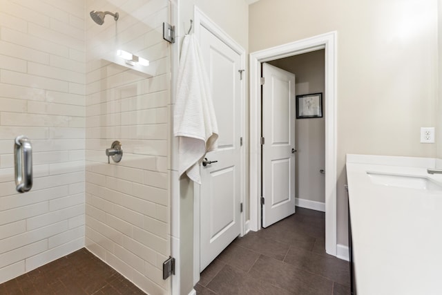 full bath with a stall shower, a sink, and tile patterned flooring