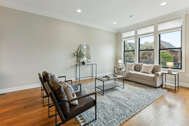 living area with visible vents, baseboards, crown molding, recessed lighting, and wood finished floors