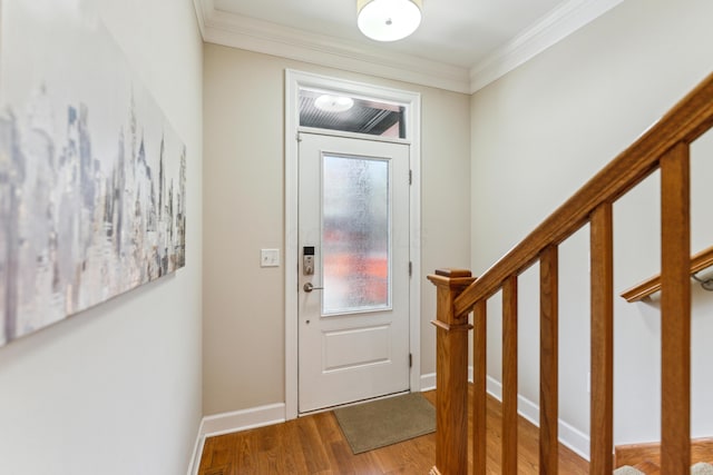 entrance foyer featuring stairs, baseboards, ornamental molding, and wood finished floors