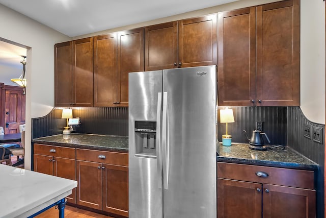 kitchen with stainless steel fridge and dark stone counters