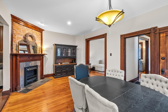 dining space with hardwood / wood-style flooring and a fireplace