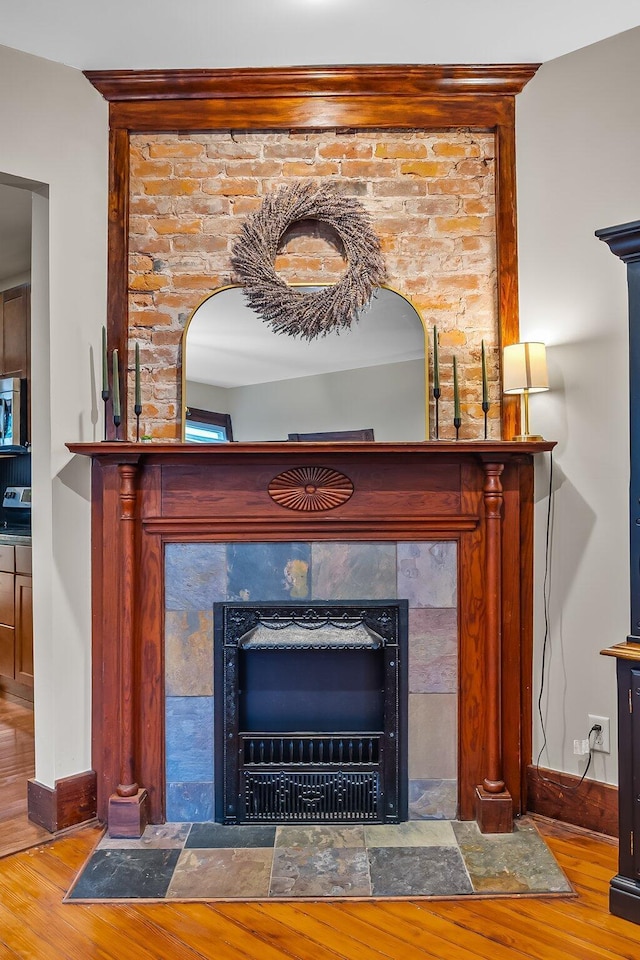 room details featuring a tile fireplace and wood-type flooring