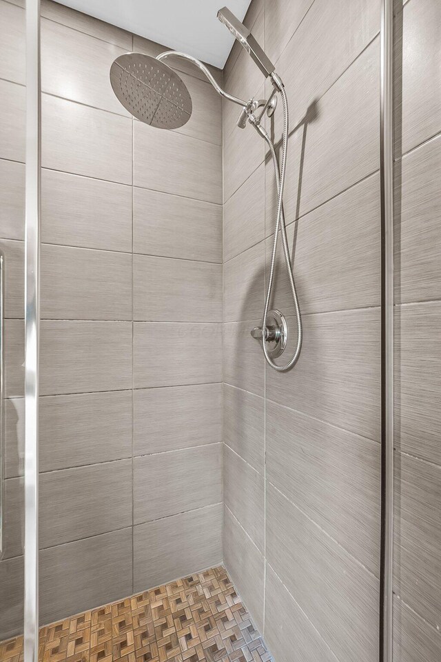 bathroom featuring parquet floors and tiled shower