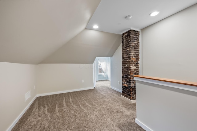 additional living space featuring carpet floors and vaulted ceiling